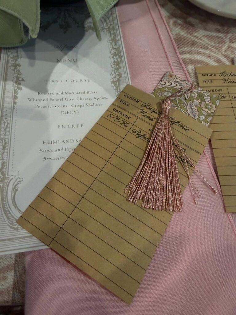 Vintage library card with a pink tassel resting on a pink wedding napkin.