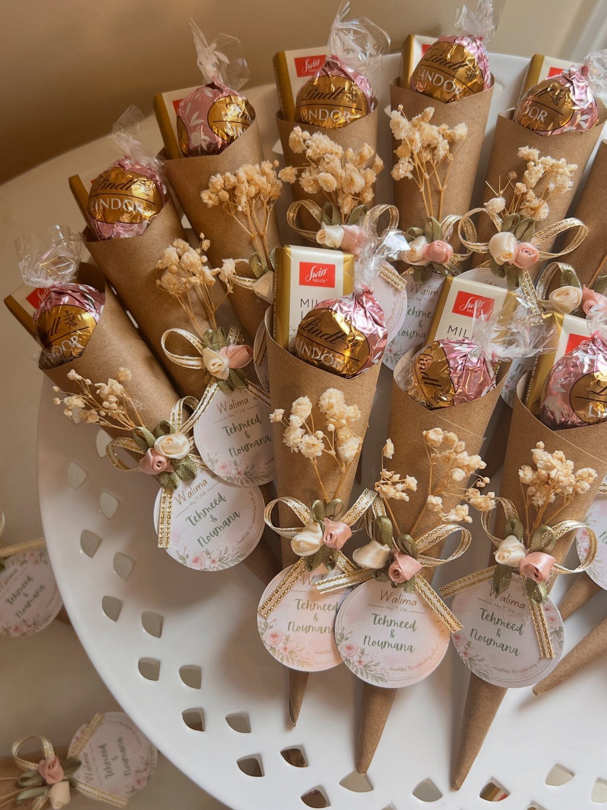 Chocolate treats in brown paper cones with dried flowers and wedding tags.
