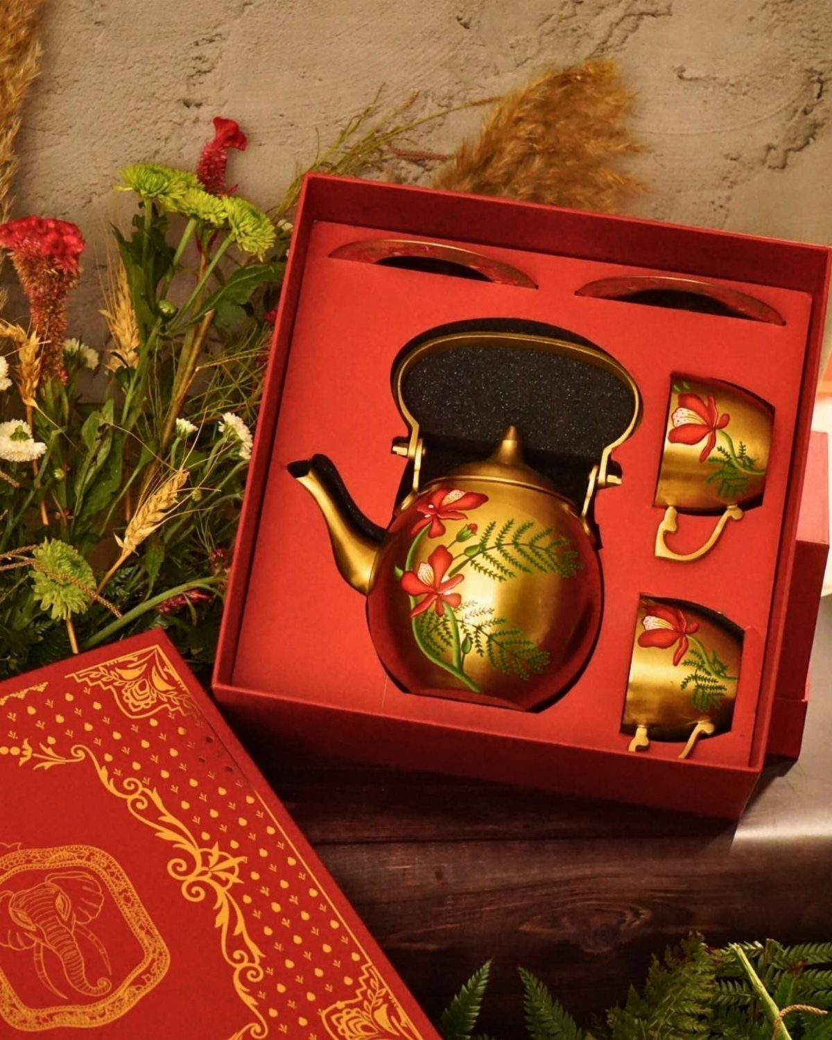 Gold painted teapot and cups set in a red gift box with floral designs