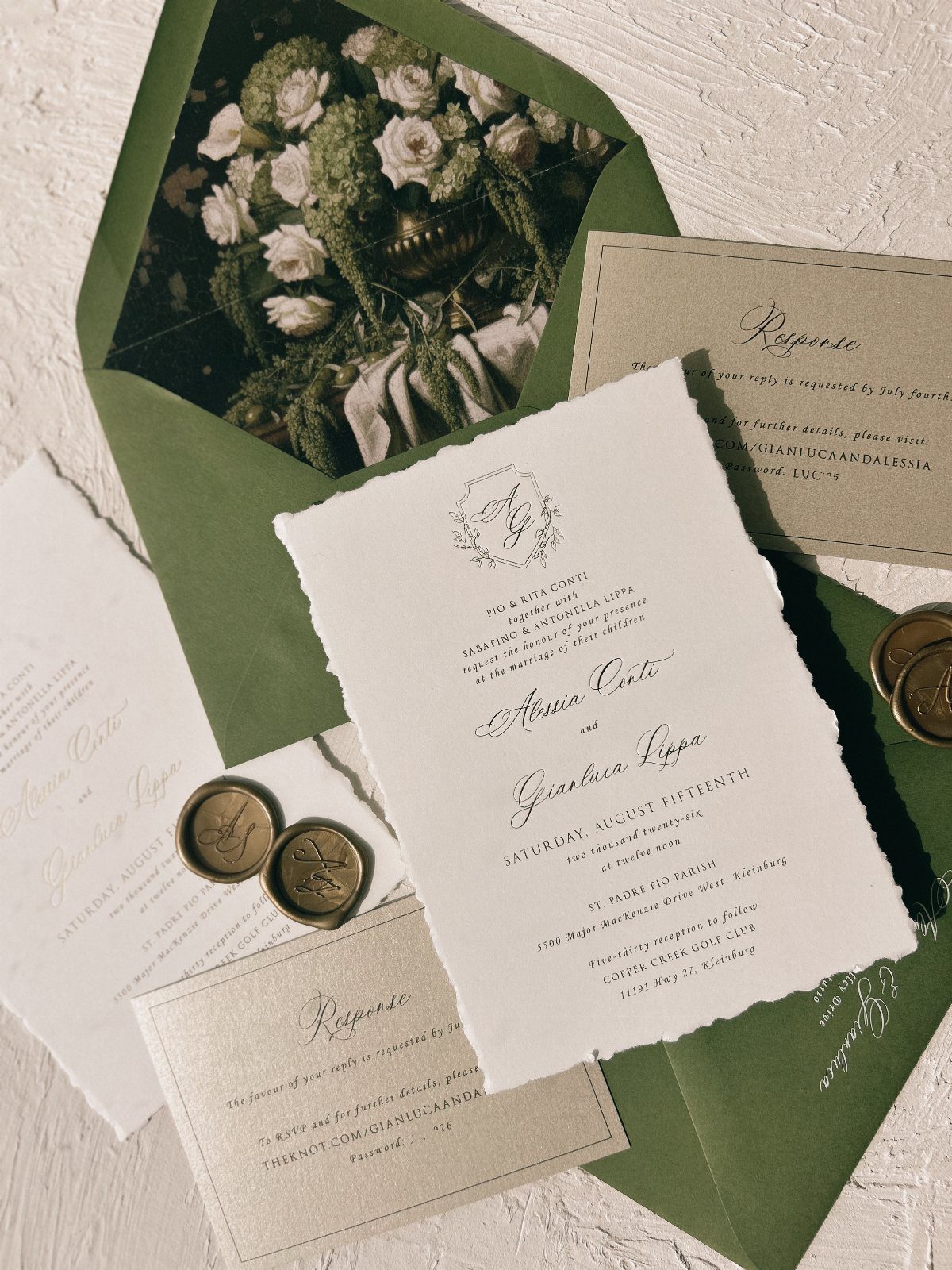 Wedding invitation suite with deckle-edged paper, green floral envelope, and gold wax seals.