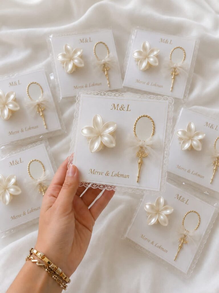 Pearl flower and gold ring ornaments packaged as wedding favors on white cards.