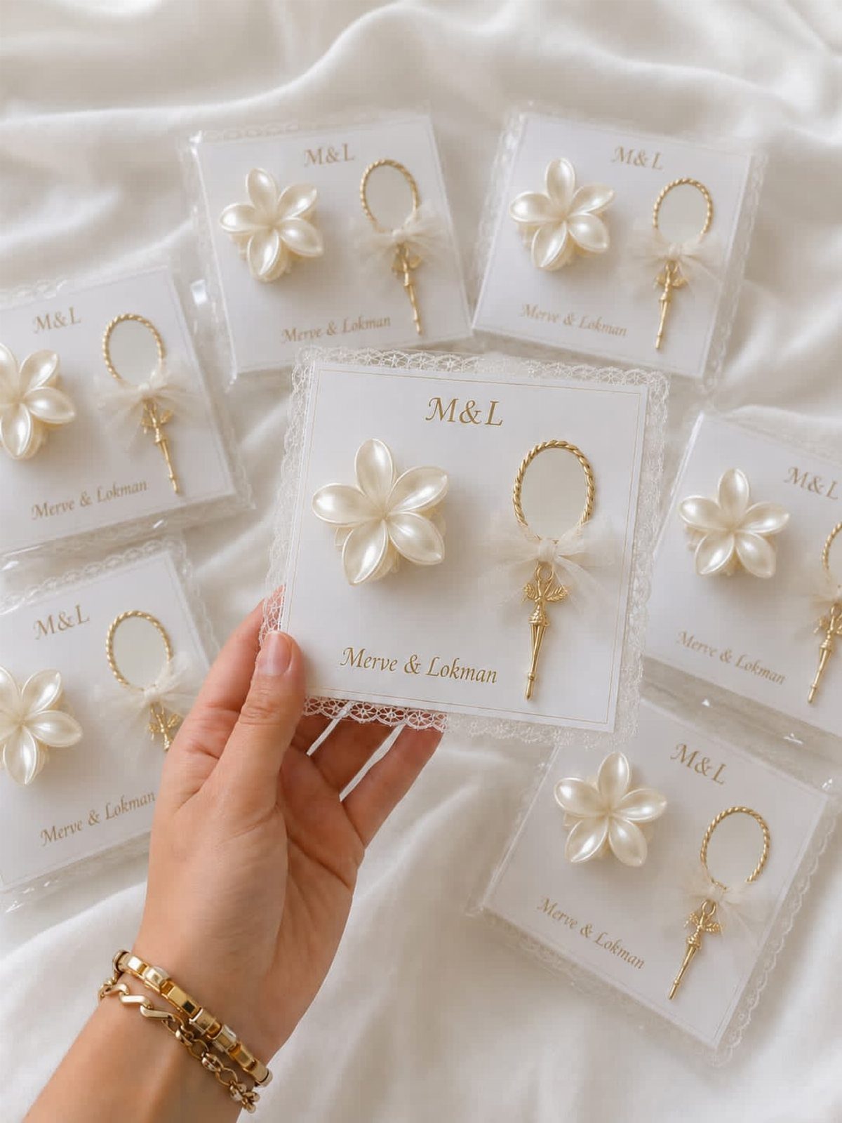 Pearl flower and gold ring ornaments packaged as wedding favors on white cards.