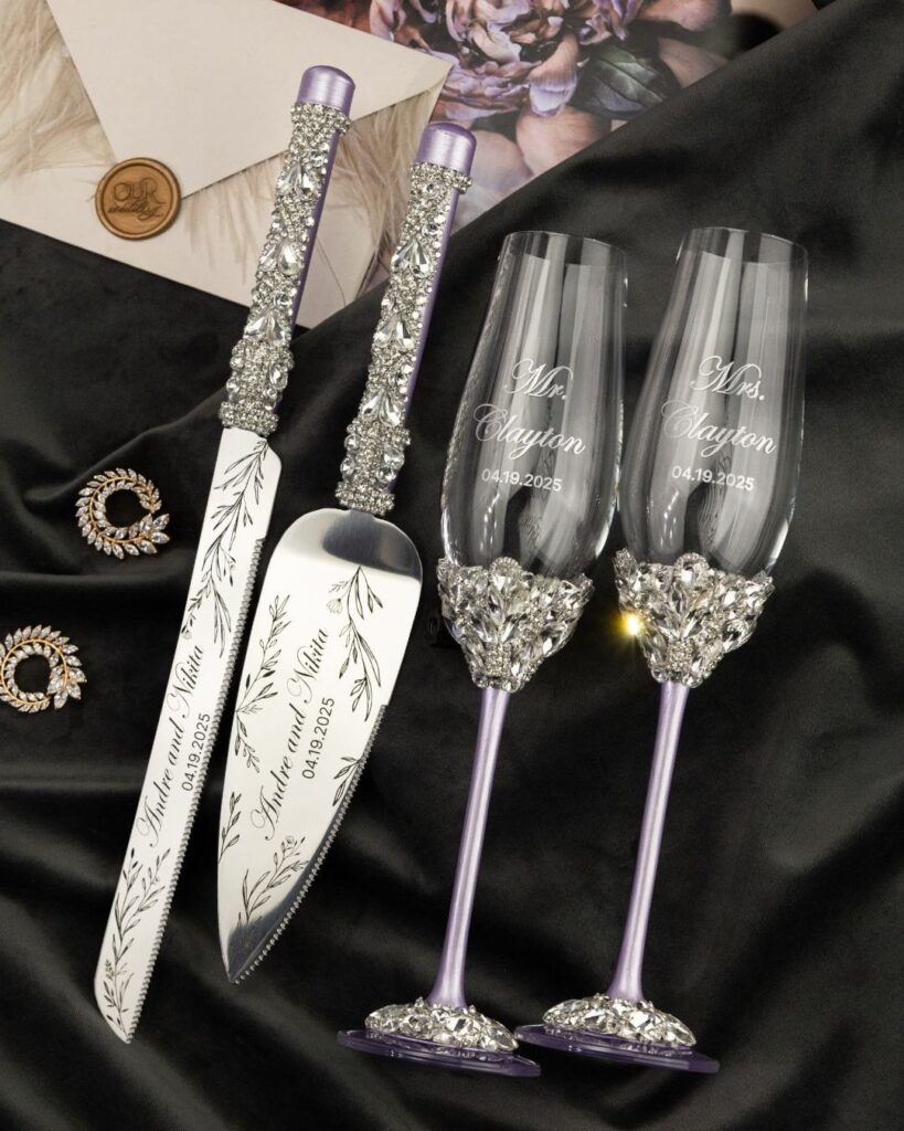 Engraved champagne flutes and cake serving set with purple crystal embellishments on black fabric