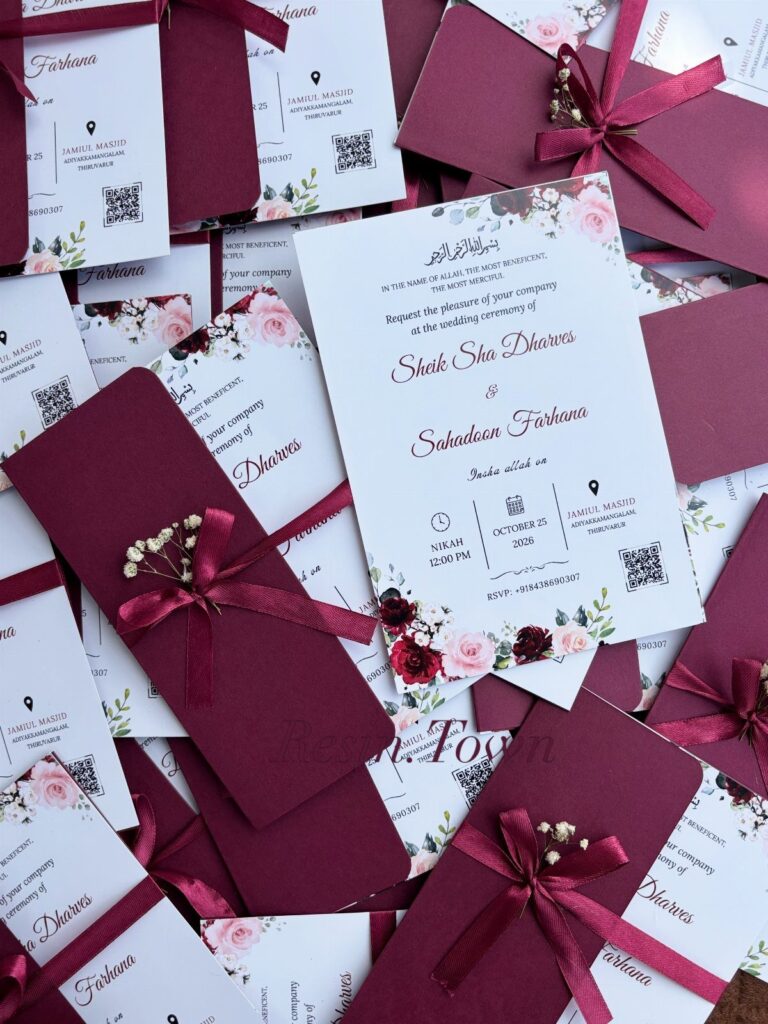 Wedding invitations with burgundy envelopes, satin ribbons, and floral designs on white cards.