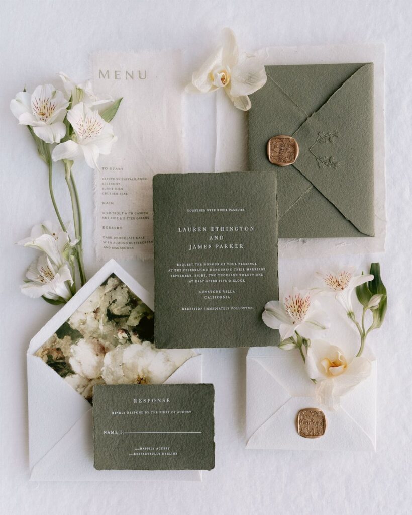 Olive green wedding invitation suite with wax seals and white floral accents
