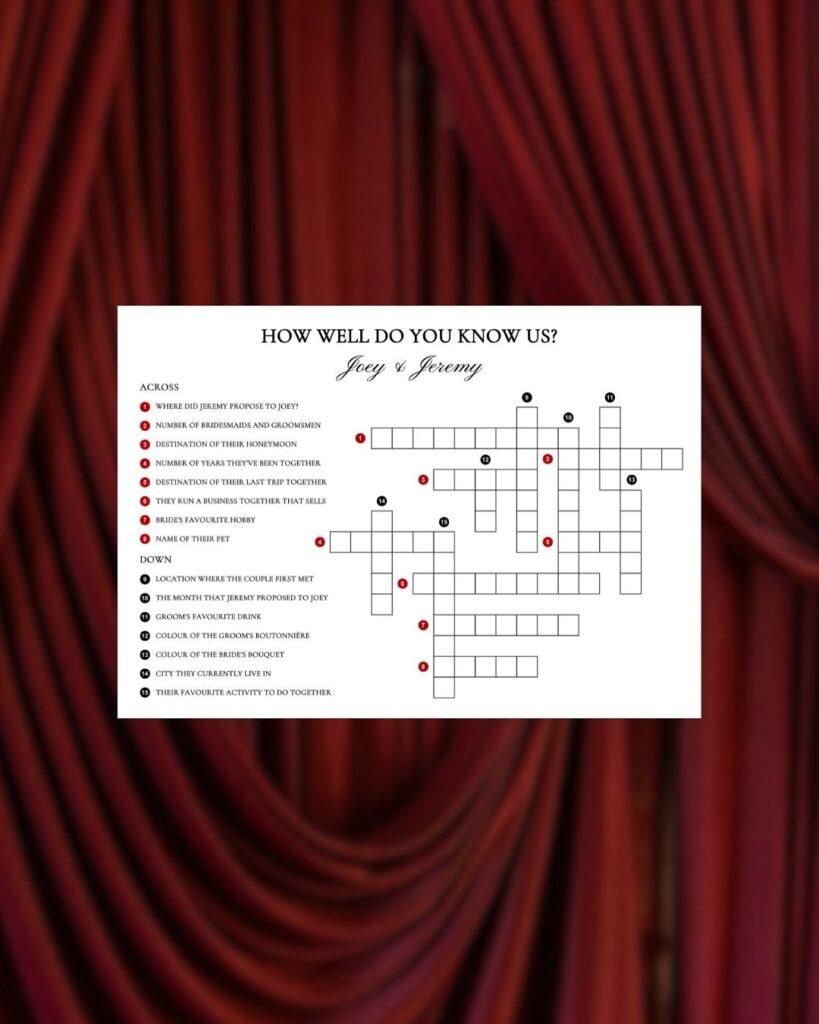 Crossword puzzle card for a wedding placed against red draped fabric background.