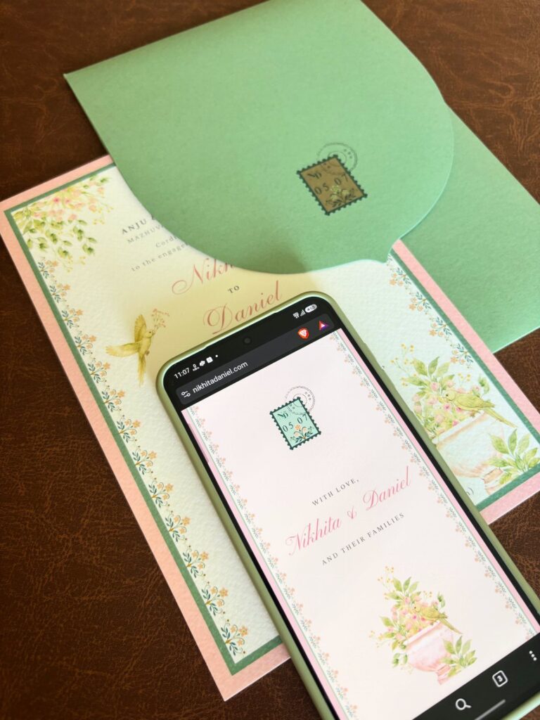 Smartphone showing a wedding website next to matching physical invitations and green envelope