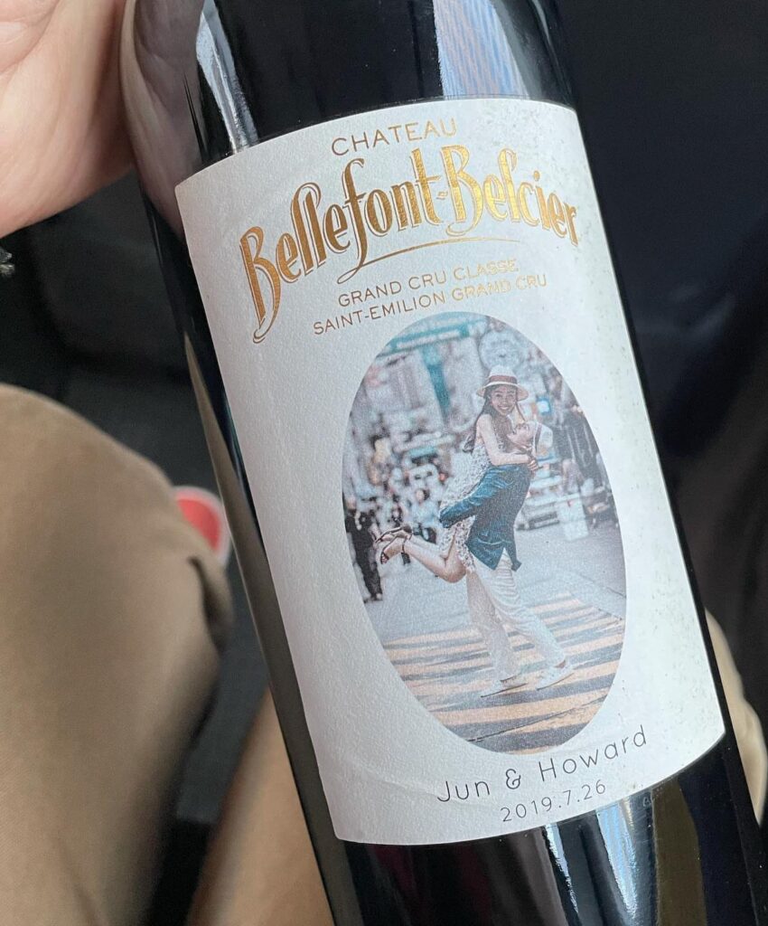 Wine bottle with a custom wedding label featuring a couple's photo and names.